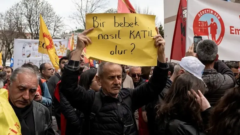 Siverek ve Kahramanmaraş saldırılarından sonra İstanbul'da düzenlenen bir protesto gösterisinde bir emekli öğretmen, üzerinde 